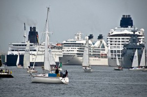 Segelboote kreuzen vor riesigen Passagierschiffen im Hafen, Personalvermittlung Staff Eins für Studentenjobs.